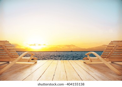 Two chaise longues at the beach with setting sun