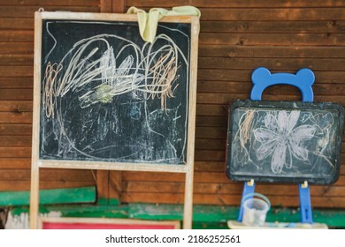 Two Chalkboards With Messy Childish Drawing In Outdoor Class, A Tilt Shift Soft Focus Shot