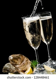 Two champagne glasses with oysters and champagne pouring