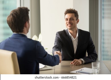 Two Cheerful Businessmen Shaking Hands Over Office Table, Starting Negotiations, Hr Greeting Applicant Arrived At Job Interview With Handshake, Good First Impression, Forming Beneficial Partnership 