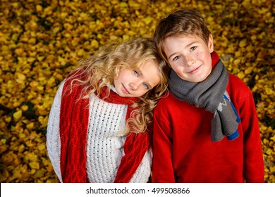 Two Cheerful Kids In A Beautiful Autumn Park. Children's Fashion. Autumn Leaf Fall.