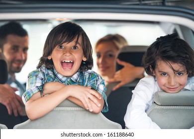 Two Cheerful Kids On A Car Backseat