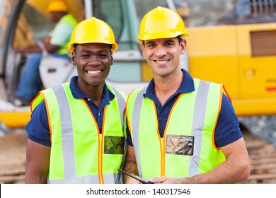 Two Cheerful Male Road Construction Workers On Construction Site