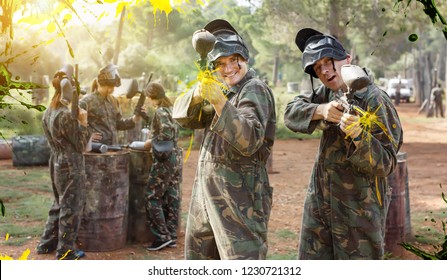 Two Cheerful Paintball Players In Full Gear Having Fun Before Game Outdoors