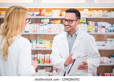 Two Cheerful Pharmacists Working On Medicines Inventory At Hospital Pharmacy. 