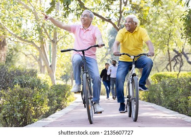 Two cheerful senior men having fun riding bicycle at park
 - Shutterstock ID 2135607727