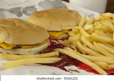 Two Cheeseburgers And French Fries On A Fast Food Bag