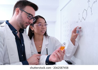 Two Chemical Students Comparing Two Medicine Vials.