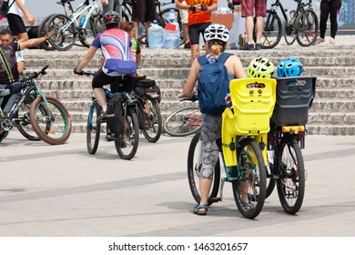 two child sits in child’s seats and bike security helmet with mother in bycicle competition, children sport equipment chairs and helmets for cycling concept