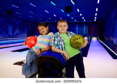 Two Children With Balls Poses In Bowling Alley