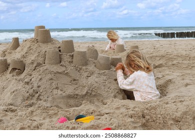 
Two children build a sandcastle on the beach. - Powered by Shutterstock