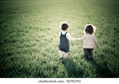Zwei Kinder gehen auf grünem Feld im Frühling