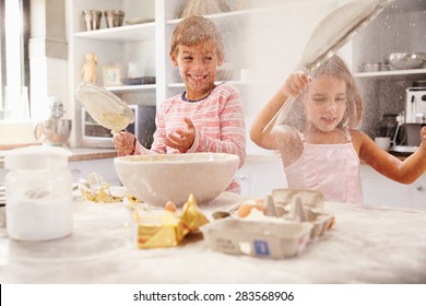 Two children having fun baking in the kitchen
