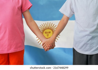 Two children joined hands on flag Argentina background. Boy and girl joined hands on background flag of Argentina. Concept of family and parenting in Argentina