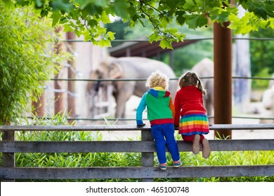 Two children, little toddler boy and preschool girl, brother and sister, watching elephant animals at the zoo on sunny summer day. Wildlife experience for kids at animal safari park.  - Shutterstock ID 465100748