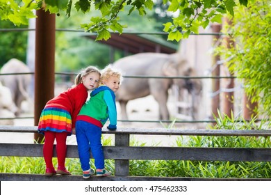 Two children, little toddler boy and preschool girl, brother and sister, watching elephant animals at the zoo on sunny summer day. Wildlife experience for kids at animal safari park.  - Shutterstock ID 475462333
