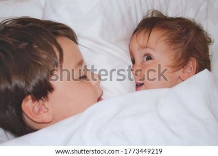 Similar – Relaxed mother and sons playing over the bed