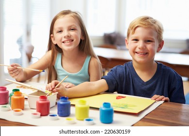 Two Children Painting Picture At Home