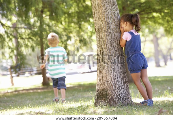 Two Children\
Playing Hide And Seek In\
Park