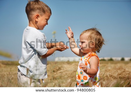 Similar – children playing in the sand, having a conversation over sand toys