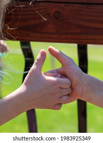 Two Children Playing A Thumb War Battle With The Objective To Pin The Opposing Player's Thumb