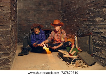 Two children in quest game solving a riddle. Pirates treasure chest.