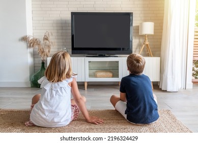 Two children sitting on the living room floor watching television. Mock up for inserting images in the tv - Powered by Shutterstock