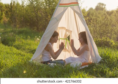 Two Children Are Sitting In A Tent Teepee