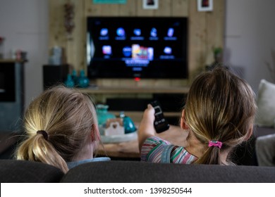 two children sliding through the apps on a smart tv. back of the children with the focus on the children