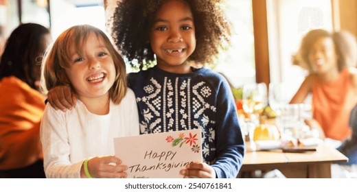 Two children smiling, holding a 'Happy Thanksgiving' card. Diverse kids, joyful moment, Thanksgiving celebration, friendship, happiness, festive atmosphere. Diverse kids holding Thanksgiving card. - Powered by Shutterstock