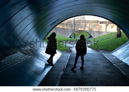 Two children talking in a pedestrian underpass