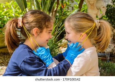 Two Children That Remove Medical Masks After The Coronavirus Quarantene And Discover Their Smiling Faces. Concept Of Freedom And Post Covid 19 Freedom. Life After Quarantine