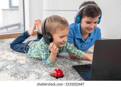 Two Children In Wireless Headphones Using Their Portable Computer