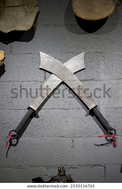 Two\
Chinese martial arts broadswords hanging on the\
wall