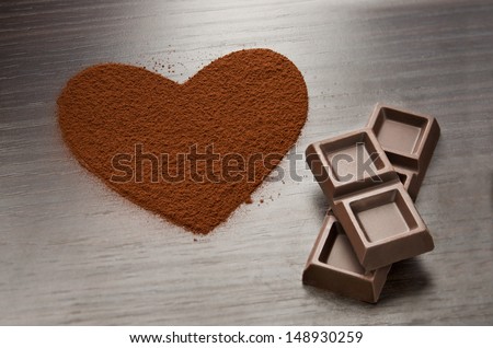 Two chocolate bars beside a heart made from cocoa powder [[stock_photo]] © 