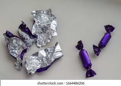 Two chocolate candies and candy wrappers. The last uneaten treats and a bunch of empty wrappers on a light background. View from above. Close-up. Selective focus. - Shutterstock ID 1664486206
