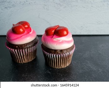 Two Chocolate Cupcakes Decorated With White And Pink Frosting And Red Hearts On A Black Slate And Gray Shiplap Background, Perfect For Love, Valentine’s Day, Mother’s Day Or A Birthday!