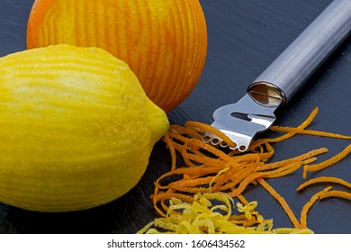 Two Citrus Fruits On A Slate Plate With Zest Peeler And Strips Of Peel