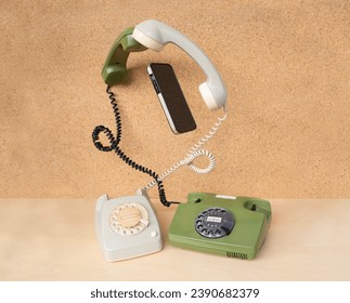 Two classic phones with levitating handsets and modern smartphone gadget, transfer technological information, experience between different generations, Bridging Past and Future - Powered by Shutterstock