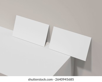 Two clean business cards leaning against soft blue wall mockup