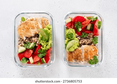 Two clear meal prep containers hold servings of chicken, quinoa, tomatoes, cucumbers, and guacamole with lime. This is good for a balanced lunch or dinner.