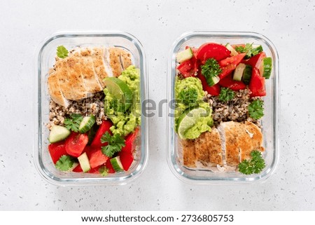 Two clear meal prep containers hold servings of chicken, quinoa, tomatoes, cucumbers, and guacamole with lime. This is good for a balanced lunch or dinner.