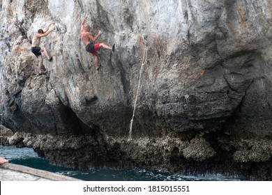 Two Climbers (men) Climb The Rock Above The Sea. Rock Climbing (deep Water Solo) In Thailand.