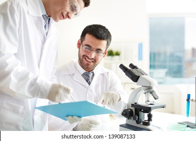 Two Clinicians Discussing Medical Document In Laboratory