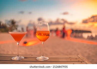 Two Cocktail Drinks With Blur Beach Party People And Colorful Sunset Sky In The Background. Luxury Outdoor Leisure Lifestyle, Relaxing And Romantic Colors, Blurred People Partying On A Summer Evening