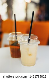 Two Cocktails In Disposable Plastic Cups. Coffee And Lemonade To Go Take Away.