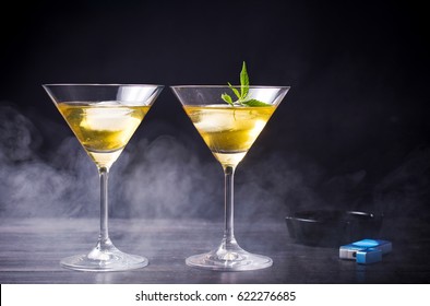 Two cocktails with marijuana against black background