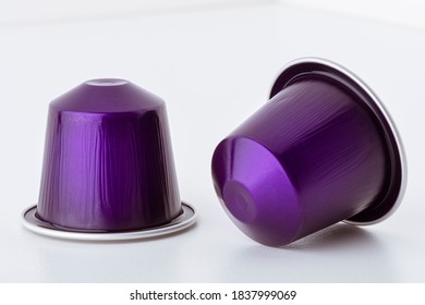 Two coffee capsules close-up on white background