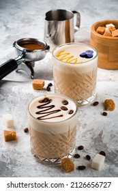 two coffee lattes close up, coffee latte macchiato with cream in glasses. Cafe latte macchiato layered coffee with coffee beans on the table - Shutterstock ID 2126656727