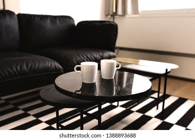 Two Coffee Mugs On Black Table  In All Black And White Room. Cool And Simple Interior Of A Student.